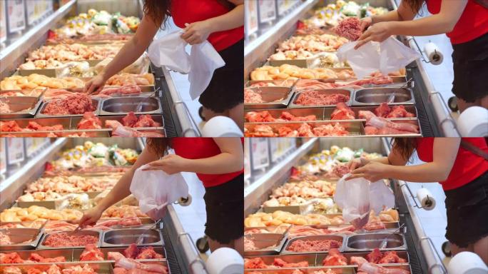 女人买肉，在超市的市场上用钳子看着鸡肉上的肉块。