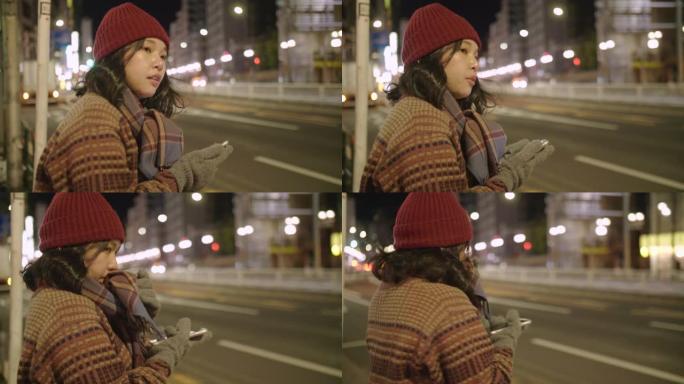 在东京市，年轻的亚洲妇女戴上羊毛帽子和围巾等出租车。