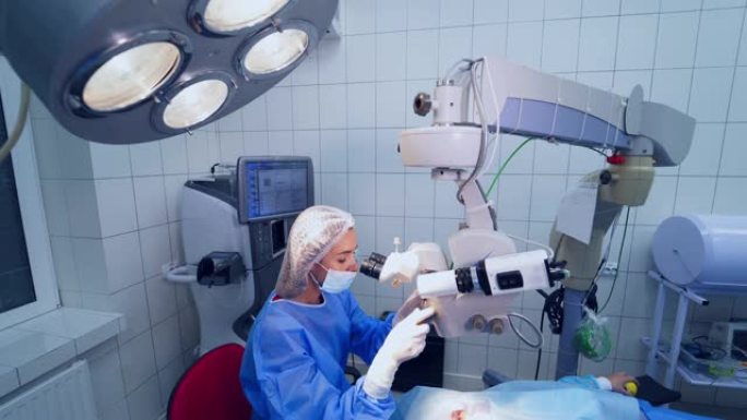 专家通过显微镜观察手术室中患者的眼睛。