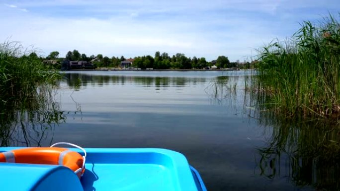带救生圈的双体水上自行车漂浮在湖芦苇大道之间的水面上