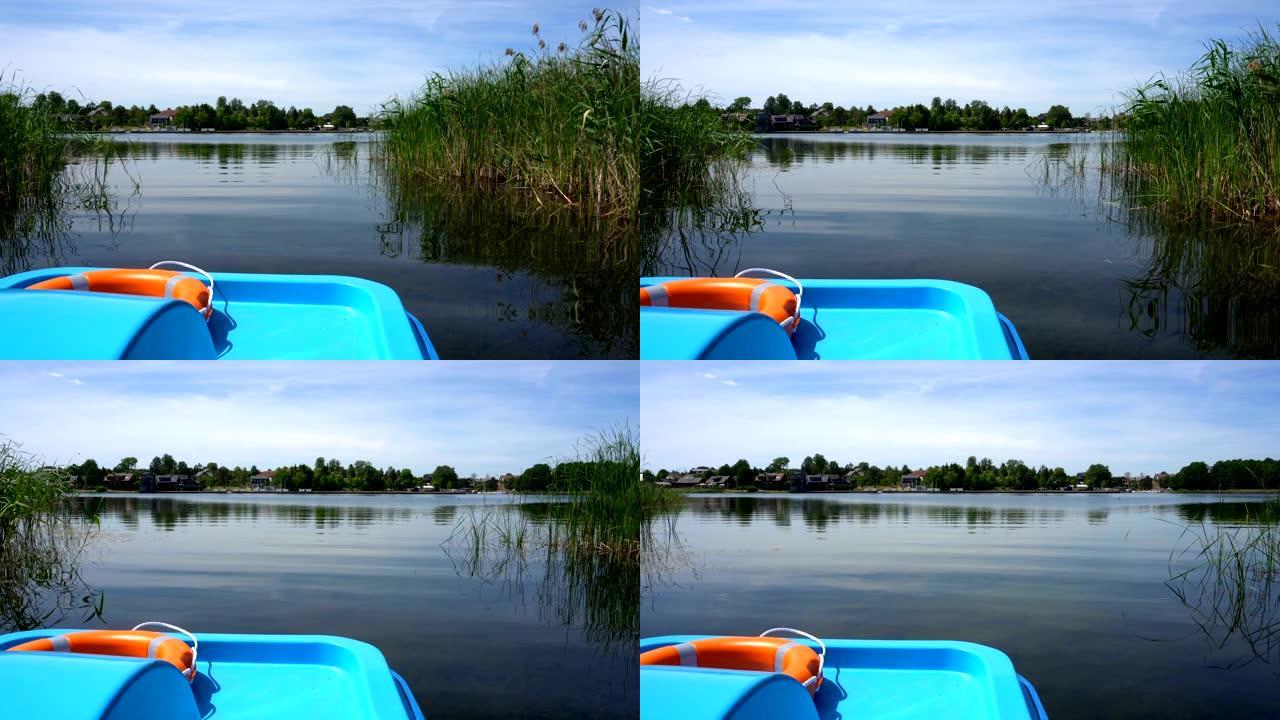 带救生圈的双体水上自行车漂浮在湖芦苇大道之间的水面上
