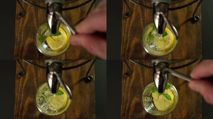 将健康的新鲜柠檬水与大水罐中的冰和薄荷倒入玻璃杯中。顶视图。