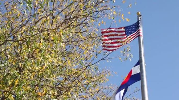风吹过的电线杆上的美国国旗和科罗拉多国旗