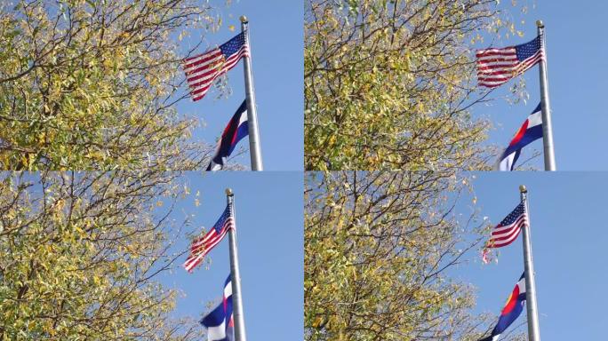 风吹过的电线杆上的美国国旗和科罗拉多国旗