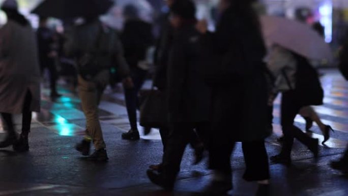 晚上在新宿东京下雨天在十字路口散步的人