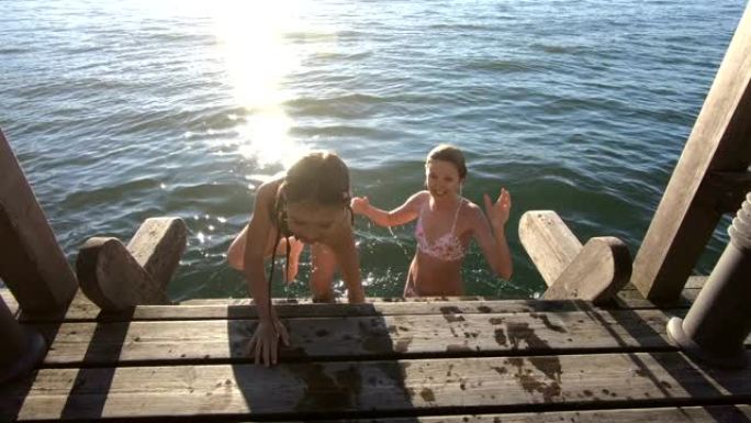 一个年轻苗条的女人带着女儿在湖里游泳