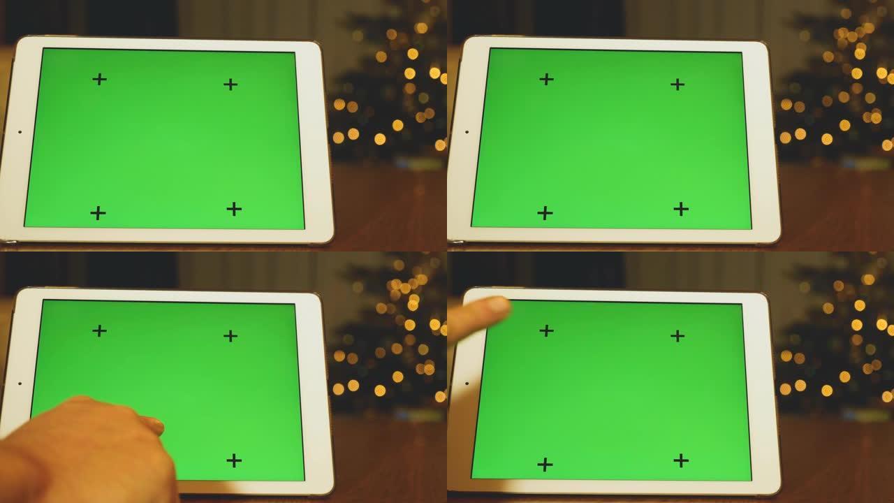 带有圣诞树背景的绿屏平板电脑