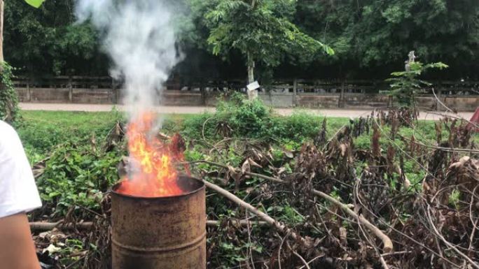 村民用金属桶焚烧垃圾。污染和空气污染概念。