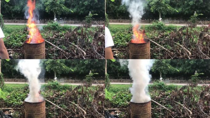 村民用金属桶焚烧垃圾。污染和空气污染概念。