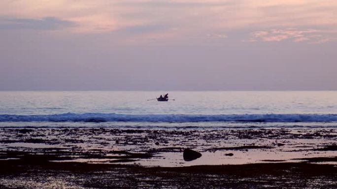 渔民在日落退潮时从船上抓鱼