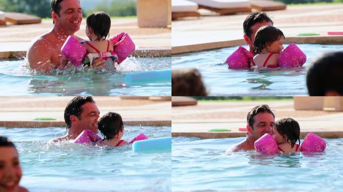 父亲和女儿在游泳池里玩耍，举起孩子