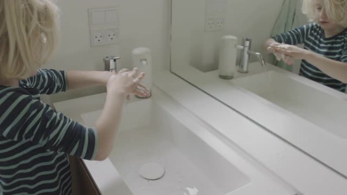 金发男孩在浴室水槽里使用消毒剂