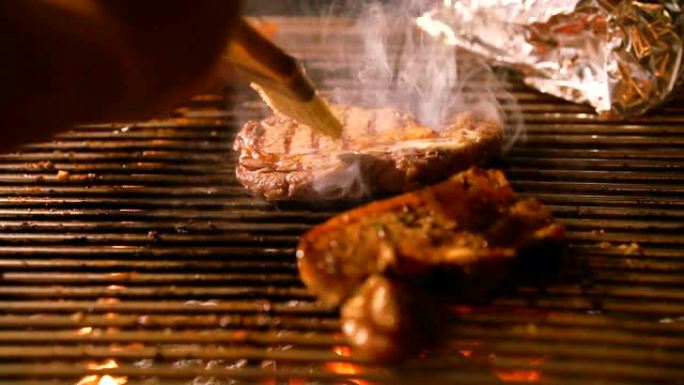 Buttering steak on flaming grill