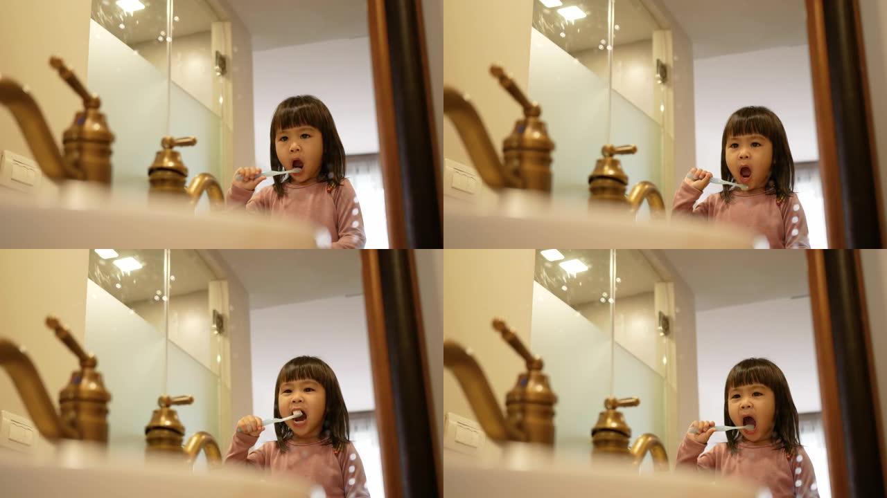 快乐的亚洲小女孩早上在浴室刷牙。口腔卫生概念。