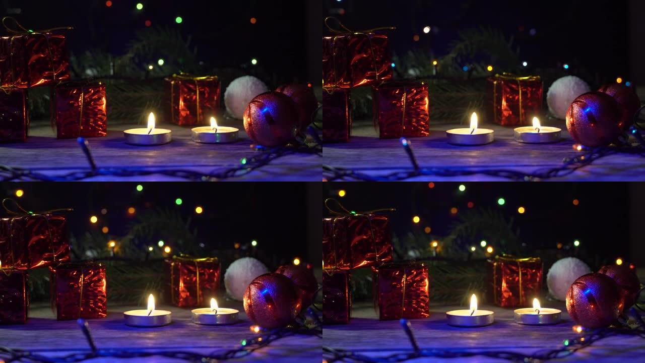 两支蜡烛在圣诞节花环，灯笼，礼物的背景上燃烧。圣诞节。