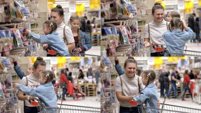 室内肖像年轻迷人的妈妈和小孩在超市买食物。幸福家庭选择带购物车产品的侧视图