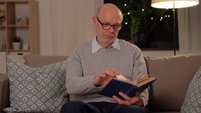 沙发上的秃头老人在家看书