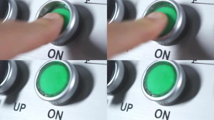 绿色按钮开机。手指按钮。在工业工厂启动发动机电气设备。带有绿色塑料圆形按钮的面板。开始工作。打开。打