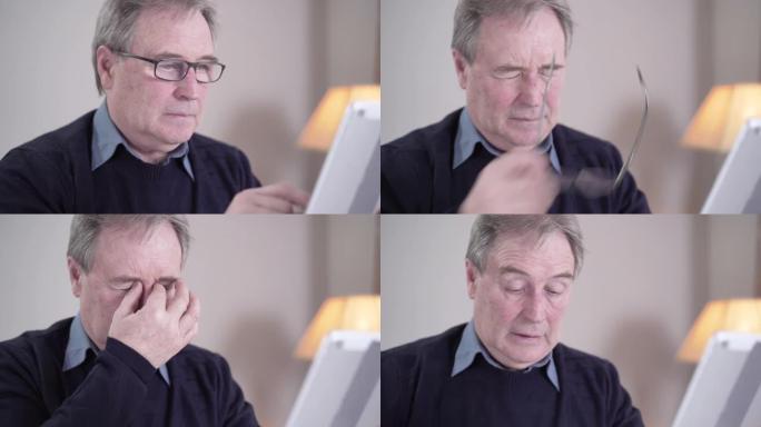 疲倦的高加索老人轻拍平板电脑屏幕，摘下眼镜和揉眼睛的特写镜头。精疲力竭的高级退休人员在室内上网时眼睛