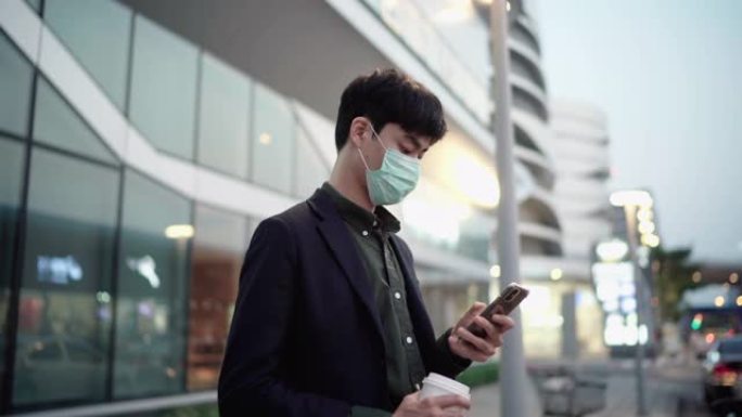 一名商人使用污染口罩并使用智能手机等待uber，出租车