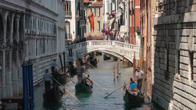 漂浮在意大利威尼斯叹息桥 (Ponte dei Sospiri) 下的运河上的吊船的延时拍摄