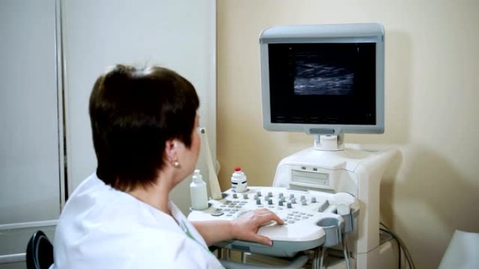 女医生使用超声波扫描仪检查妇女的腹部器官。高清