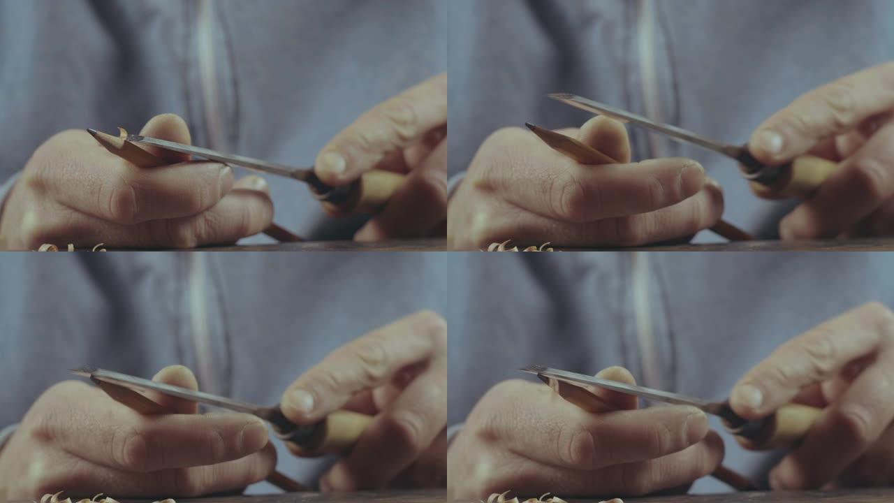 男性双手用凿子削尖铅笔的特写镜头。削尖一支简单的铅笔。电影4k视频