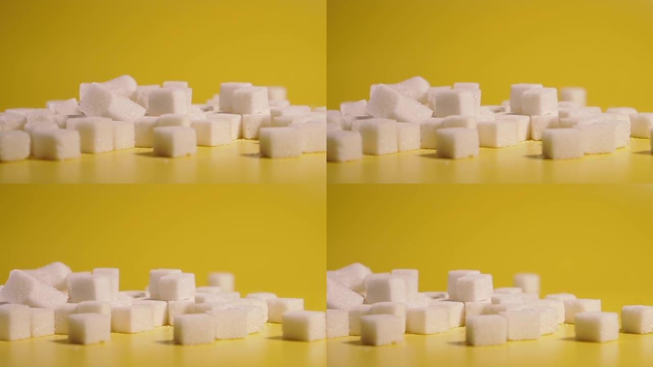糖。方块中的糖位于黄色背景上。