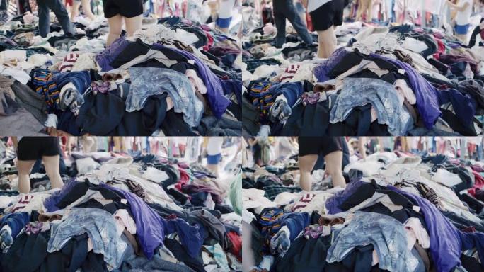 人们在泰国市场上挑选衣服。