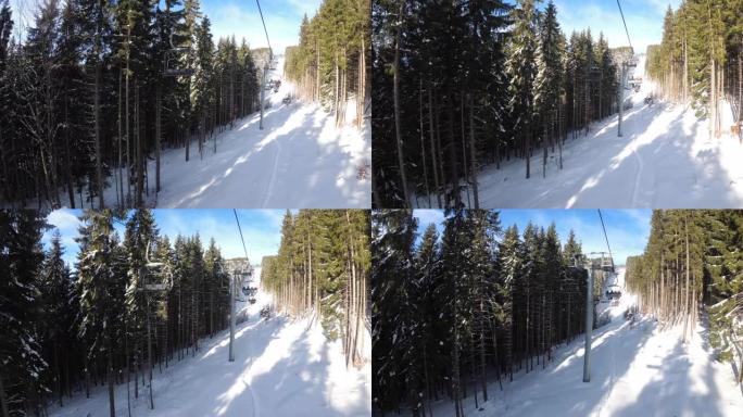 来自松树林和索道上滑雪者之间的滑雪椅升降机的POV