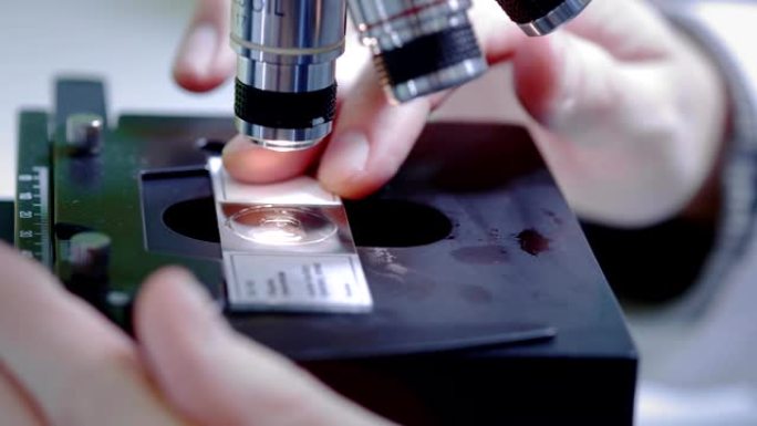 科学家通过显微镜观察。更改样本。开展科研工作。他正在研究一种病毒，寻找一种流行疫苗的治疗方法