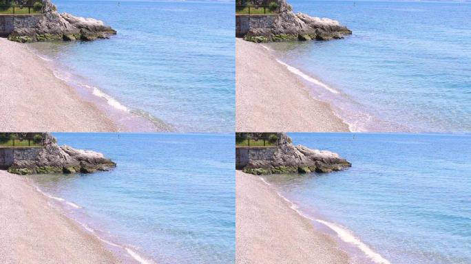 海滨海滩上的壮丽景色，蔚蓝的水，黄沙和照片角落的一块小石头。美丽的亚得里亚海海边，有黄白色的沙子和干