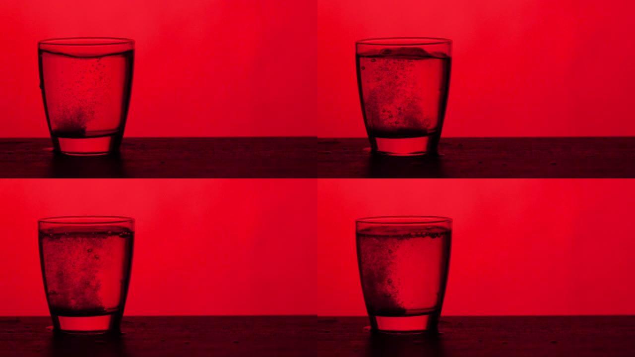 泡腾片滴入一杯水红色背景，慢动作