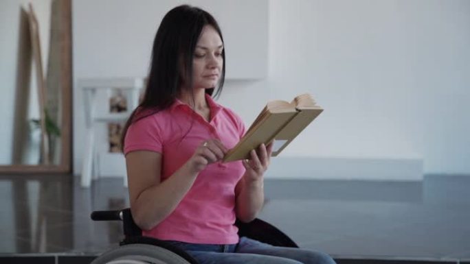 残疾年轻女子坐在公寓房间的轮椅上读书