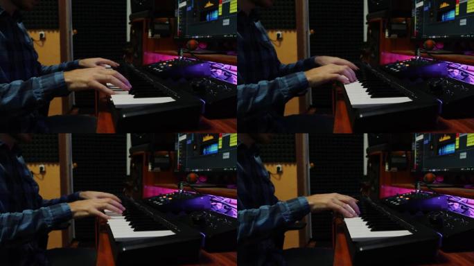 家庭音乐工作室里的人手演奏钢琴midi键盘。男手指弹钢琴，为新专辑录制歌曲。音乐创作过程。音乐家在数