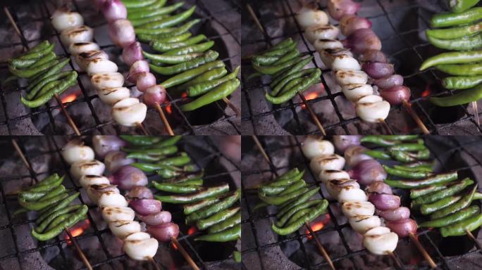 大蒜，去皮的大蒜和绿辣椒配串在炉子上烤。烧烤。野餐派对。蔬菜。