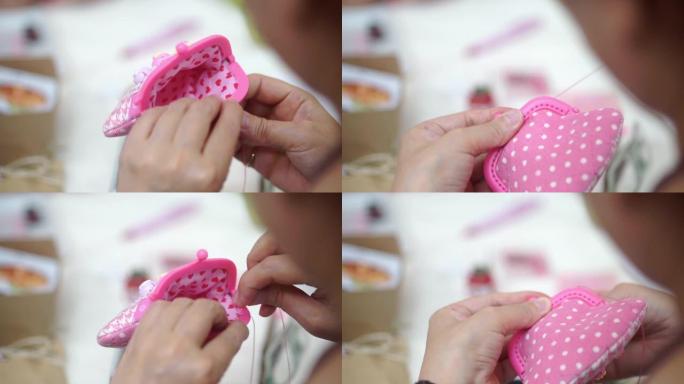 用针用手缝制织物，制成粉红色口袋。