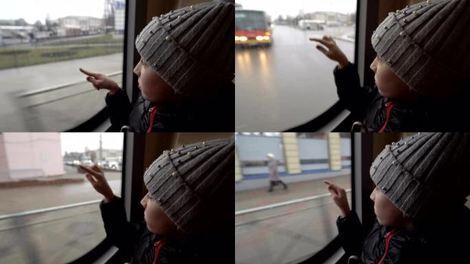 特写镜头，一个孩子-一个小女孩，坐在后座坐在公共汽车上，在玻璃上画画。汽车从窗外经过。从公共汽车里面