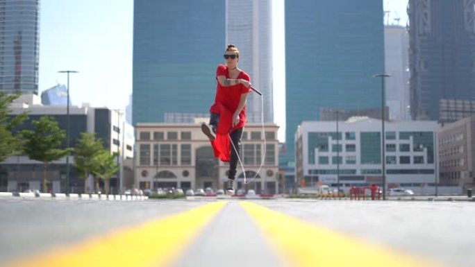 迪拜城市景观背景下跳绳跳跃的年轻女孩慢动作