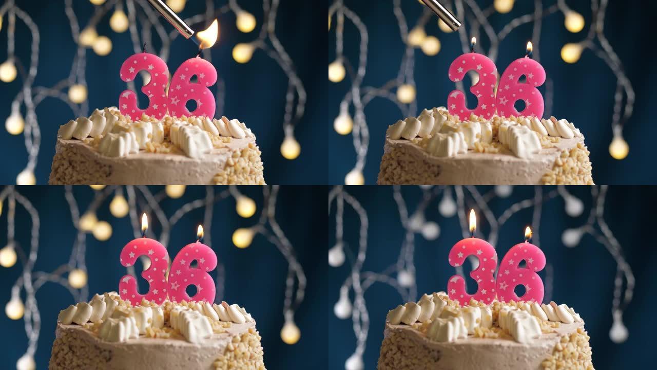 蓝色背景上有36号粉色蜡烛的生日蛋糕。蜡烛着火了。慢动作和特写视图