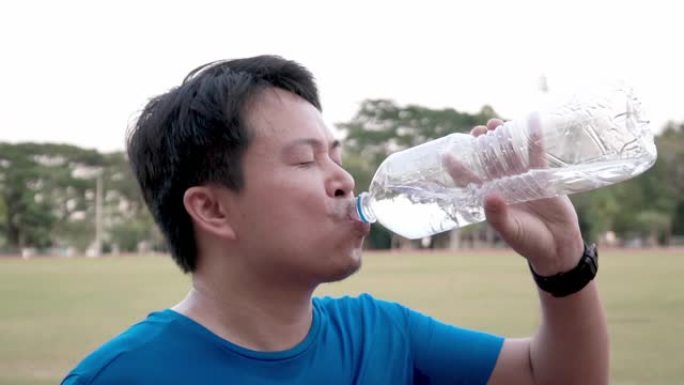男子跑步后喝水。体育锻炼