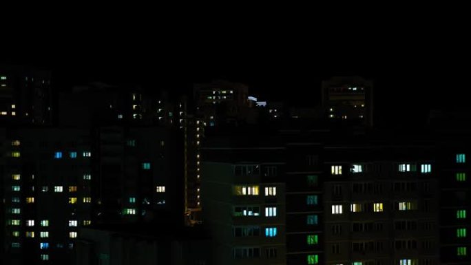 多层建筑时间流逝的窗户中的夜晚全景。夜屋，夜城