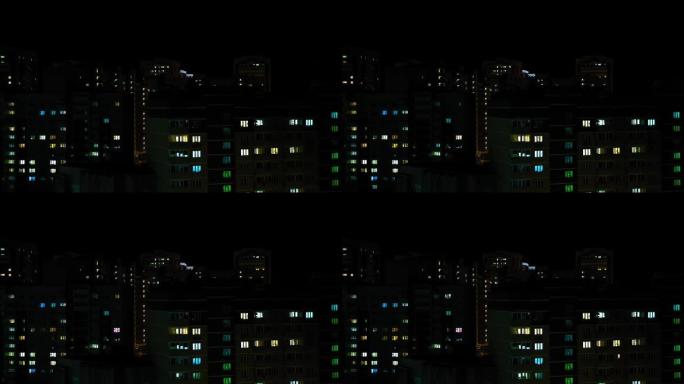 多层建筑时间流逝的窗户中的夜晚全景。夜屋，夜城