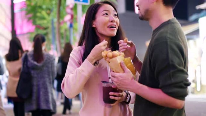 SLO MO掌上电脑拍摄了一对年轻夫妇在香港吃传统街头食品的镜头
