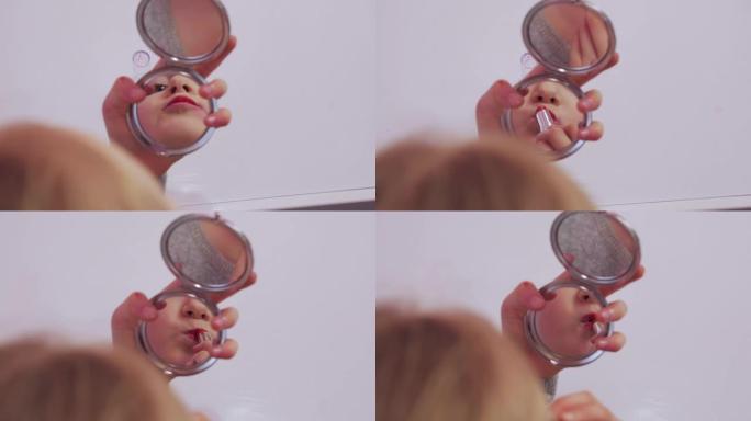 小女孩在镜子里画嘴唇