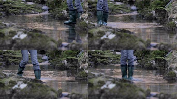 无法识别的成年妇女探索溪流并穿着靴子踩水