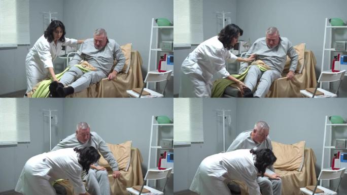 医生帮助老人从医院的床上起床