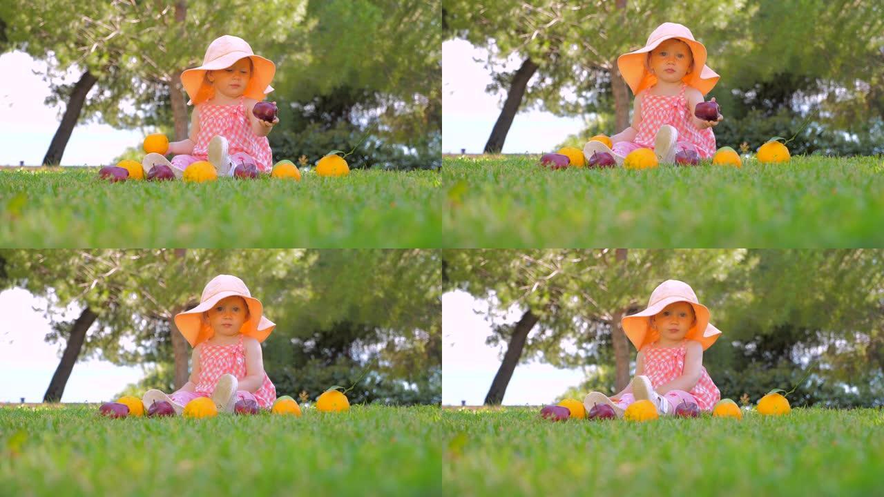 小公主在户外玩水果。巴拿马的孩子在后院户外玩得开心。快乐的童年概念。蹒跚学步的孩子坐在绿草地上等待母