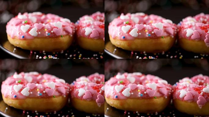 洒水落在粉红色甜甜圈上，带有心形洒水-滑动镜头