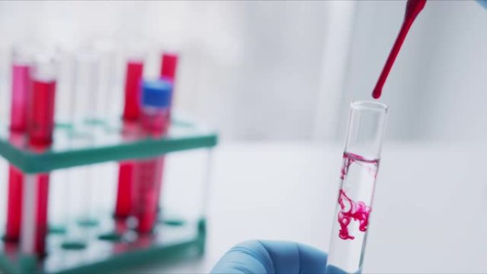 用移液器分析红色液体以提取DNA的科学家